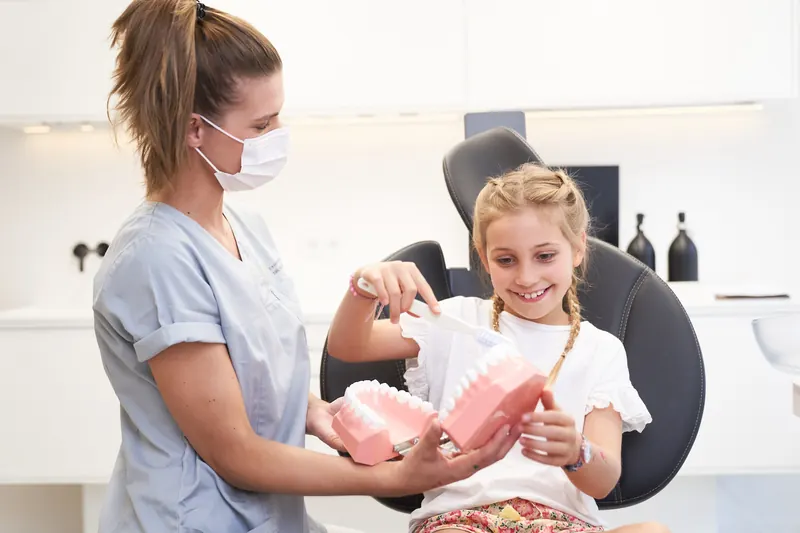 Dentist explaining tooth care to a girl